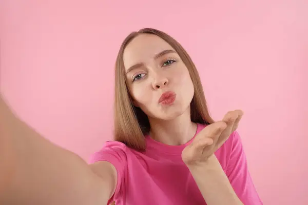 Junge Frau Macht Selfie Und Pustet Kuss Auf Rosa Hintergrund — Stockfoto