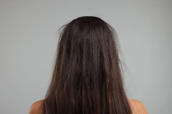 Femme Aux Cheveux Abîmés Sur Fond Gris Vue Arrière — Photo