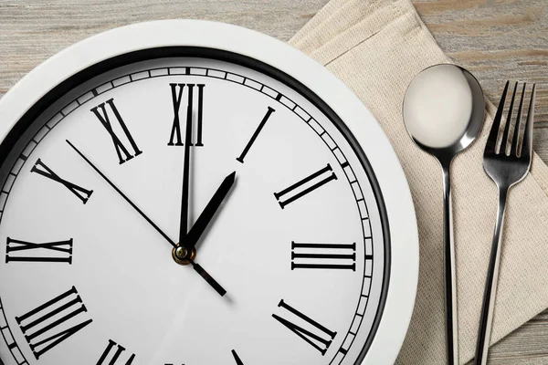 Zegar Ścienny Sztućce Jasnym Drewnianym Stole Zbliżenie Koncepcja Lunchu Biznesowego — Zdjęcie stockowe