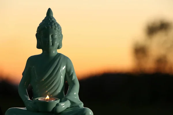 Dekorativ Buddha Staty Med Brinnande Ljus Utomhus Vid Solnedgången Plats — Stockfoto