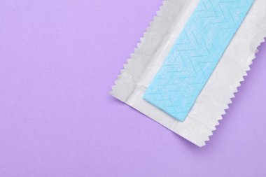 Menekşe arkaplanda sakız paketi açık, üst görünüm. Metin için boşluk