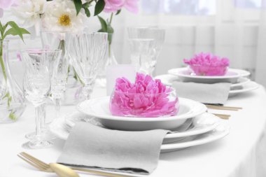 Yemek odasında güzel şakayıklar olan şık bir masa, yakın plan.