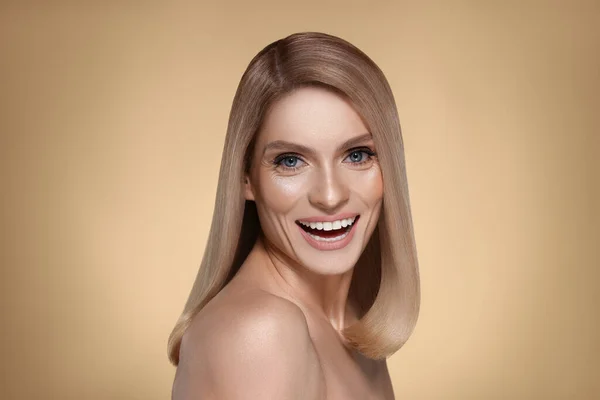 Portret Atrakcyjnej Kobiety Blond Włosami Uśmiechniętymi Ciemnym Beżowym Tle — Zdjęcie stockowe
