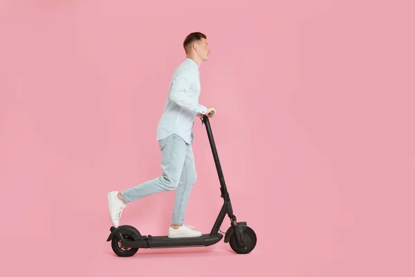 Joven Montando Moderno Scooter Patada Eléctrica Sobre Fondo Rosa — Foto de Stock