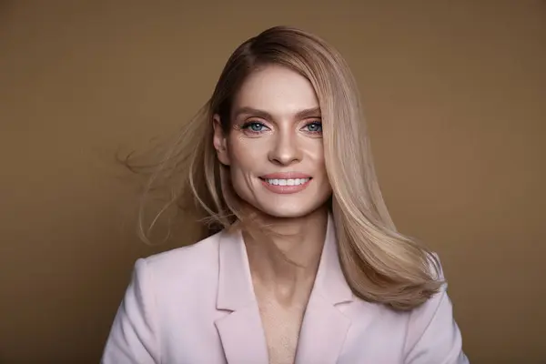 Portret Stylowej Atrakcyjnej Kobiety Blond Włosami Uśmiechniętymi Pastelowym Brązowym Tle — Zdjęcie stockowe