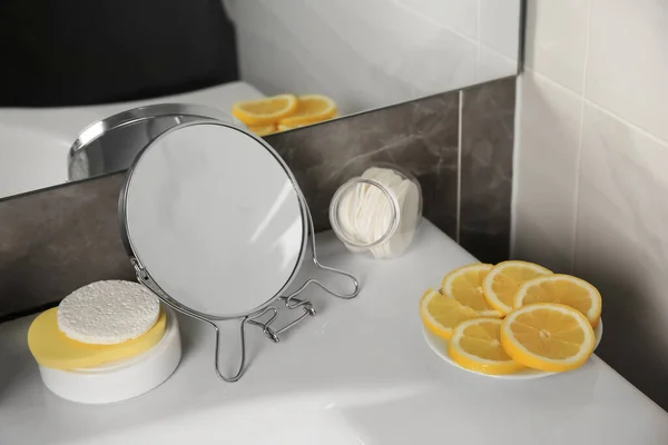 Lemon face wash. Fresh citrus fruits, personal care products and mirror on sink in bathroom