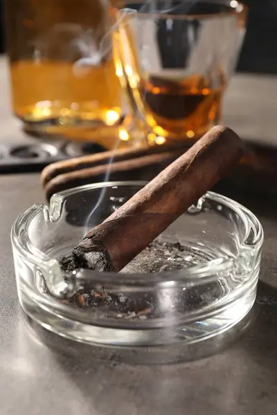 Schwelende Zigarre Aschenbecher Und Whiskey Auf Grauem Tisch Nahaufnahme — Stockfoto