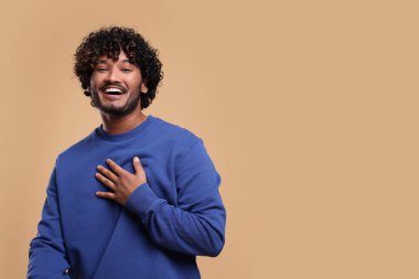 Bej arka planda gülümseyen yakışıklı genç adam, metin için boşluk