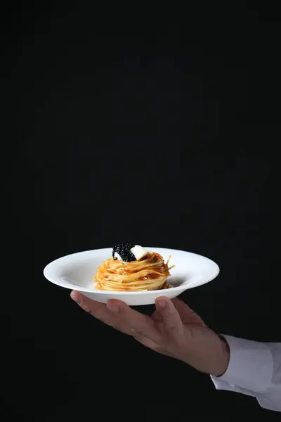 Kellner Hält Teller Mit Leckeren Spaghetti Mit Tomatensauce Und Schwarzem — Stockfoto