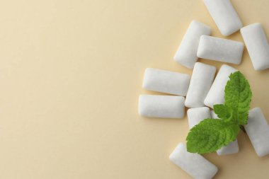 Lezzetli beyaz sakız ve bej arka planda nane yaprakları, düz yatış. Metin için boşluk