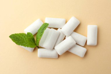 Lezzetli beyaz sakız ve bej arka planda nane yaprakları, üst görünüm