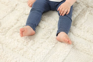 Bebek yumuşak halıda oturuyor, yakın çekim manzarası