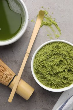 Yeşil kibrit tozu ve açık gri masada taze içecek içeren düz bir kompozisyon.