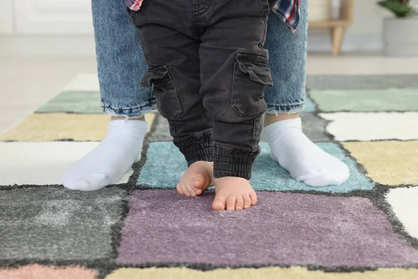 Madre Apoyando Hijo Mientras Aprende Caminar Alfombra Interior Primer Plano — Foto de Stock