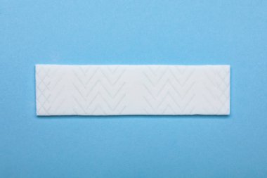 Açık mavi arkaplanda lezzetli sakız, üst görünümde.