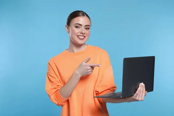 Ευτυχισμένη Γυναίκα Δείχνει Laptop Ανοιχτό Μπλε Φόντο — Φωτογραφία Αρχείου
