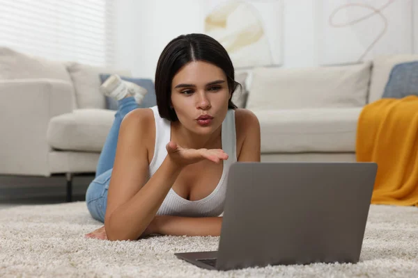 Młoda Kobieta Wideo Czat Przez Laptopa Dmuchanie Pocałunek Podłodze Domu — Zdjęcie stockowe