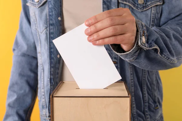 Homem Colocando Seu Voto Urna Fundo Amarelo Close — Fotografia de Stock