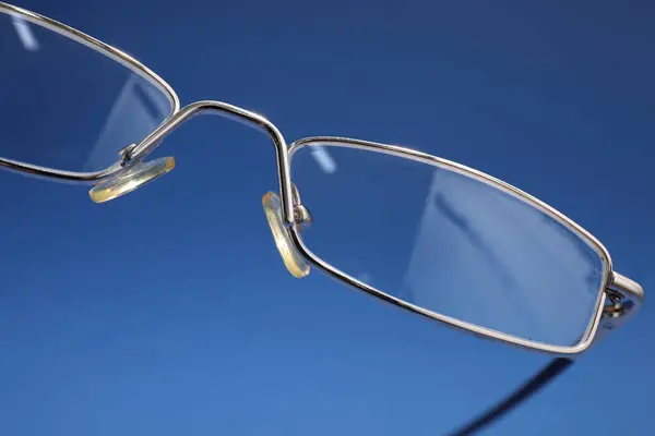 Stijlvol Paar Glazen Met Metalen Frame Blauwe Achtergrond Close — Stockfoto