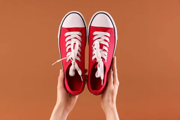 Kahverengi Arka Planda Klasik Kırmızı Spor Ayakkabılı Kadın Yakın Plan — Stok fotoğraf