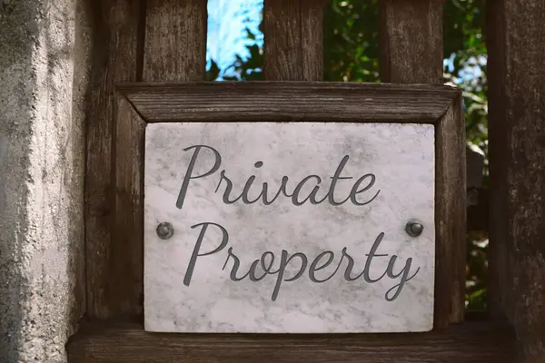 Sign with text Private Property on wooden fence