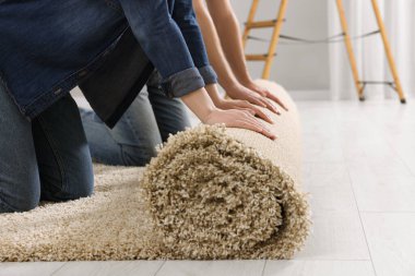 Odada yeni halı seren çift, yakın plan.