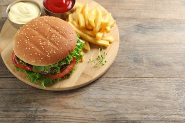 Manzaranın üstünde köfteli leziz burger, sos ve patates kızartması var. Metin için boşluk