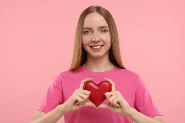 Feliz Joven Sosteniendo Corazón Rojo Sobre Fondo Rosa — Foto de Stock
