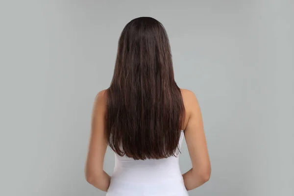 Frau Mit Beschädigten Unordentlichen Haaren Auf Grauem Hintergrund Rückseite — Stockfoto