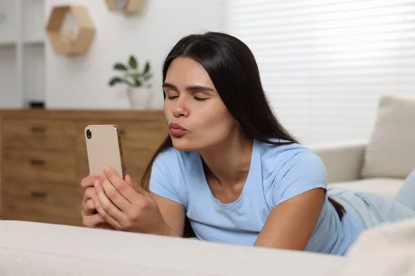 Młoda Kobieta Wideo Czat Pośrednictwem Smartfona Wieje Pocałunek Kanapie Salonie — Zdjęcie stockowe