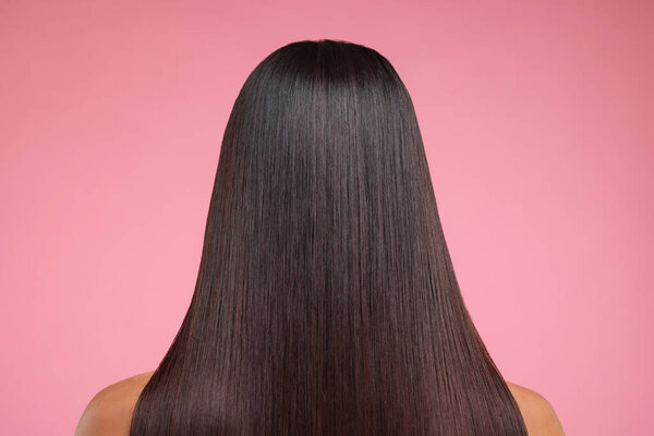 Woman with healthy hair after treatment on pink background, back view