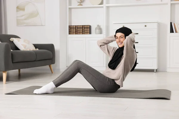 穆斯林妇女在家中的健身垫上做腹肌运动 — 图库照片