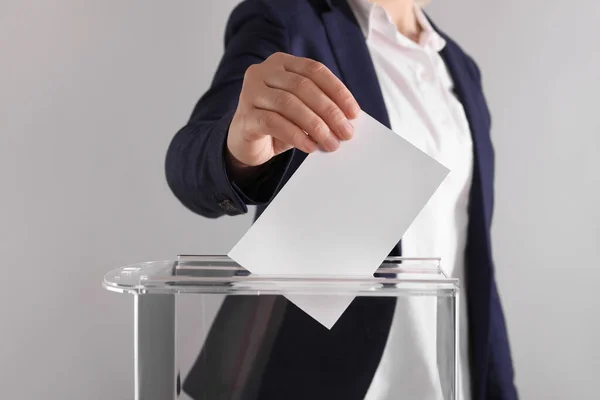 Kvinde Sætter Sin Stemme Stemmeurnen Lysegrå Baggrund Closeup - Stock-foto