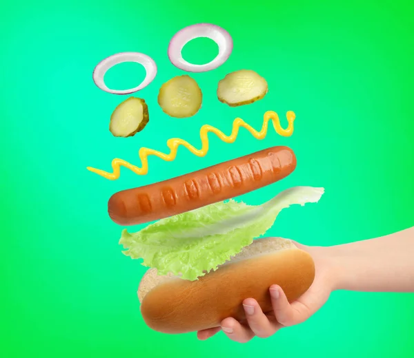 Frau Macht Hot Dog Auf Grünem Hintergrund Nahaufnahme Zutaten Schweben — Stockfoto