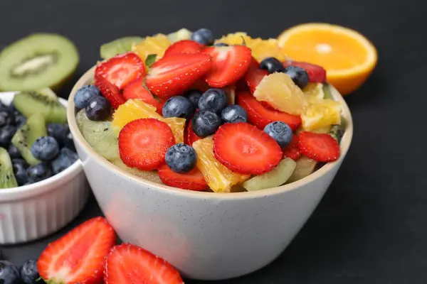 Νόστιμα Φρέσκα Φρούτα Σαλάτα Μπολ Και Συστατικά Σκούρο Τραπέζι Closeup — Φωτογραφία Αρχείου