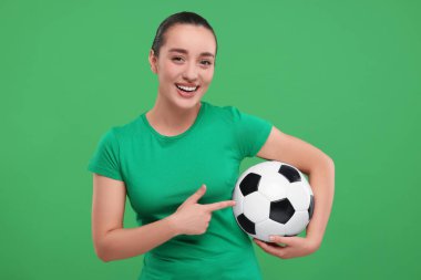 Yeşil arka planda futbol topunu gösteren Happy taraftarı