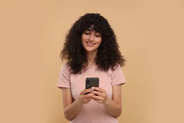 Ευτυχισμένη Νεαρή Γυναίκα Που Χρησιμοποιεί Smartphone Μπεζ Φόντο — Φωτογραφία Αρχείου