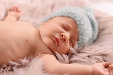 Şirin yeni doğmuş bebek pofuduk battaniyenin üzerinde uyuyor, yakın plan.