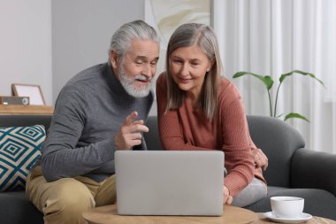 Dizüstü bilgisayarlı yaşlı çift odada emeklilik planlarını tartışıyor