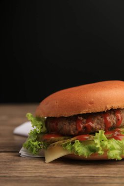 Köfteli lezzetli bir hamburger, ahşap masada marul ve peynir, yakın plan. Metin için boşluk