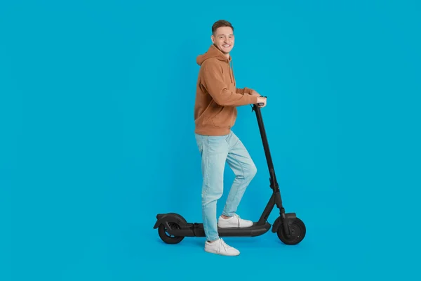 Homem Feliz Com Moderno Scooter Elétrico Pontapé Fundo Azul Claro — Fotografia de Stock