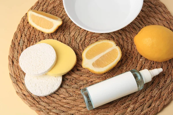 Lemon face cleanser. Fresh citrus fruits and personal care products on wicker mat, closeup