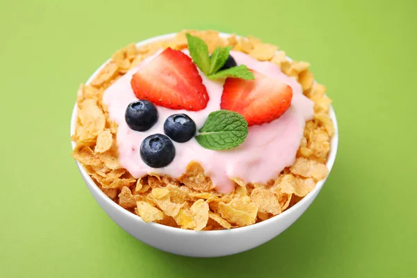美味的脆玉米片 酸奶和新鲜的浆果碗绿色背景 健康早餐 — 图库照片
