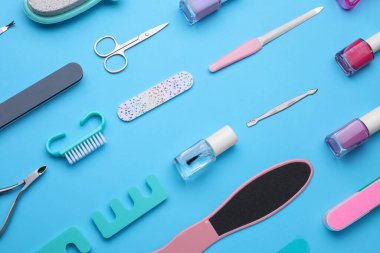 Açık mavi arkaplan üzerinde pedikür araçları kümesi, düz yatıyordu