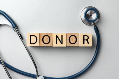 Kelime donörü, tahta küplerden ve steteskoptan yapılmış açık gri masada, düz yatıyordu.