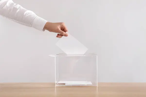 Woman Putting Her Vote Ballot Box Wooden Table Light Grey — Stock Photo, Image