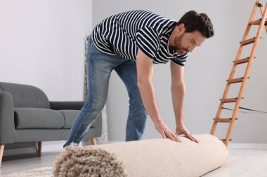 Odada yeni temiz halı seren bir adam