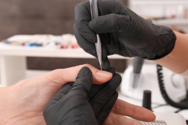 Müşteriyle kuaförde çalışan profesyonel manikürcü.