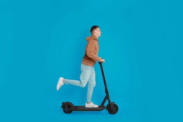 Joven Montando Moderno Scooter Patada Eléctrica Sobre Fondo Azul Claro — Foto de Stock