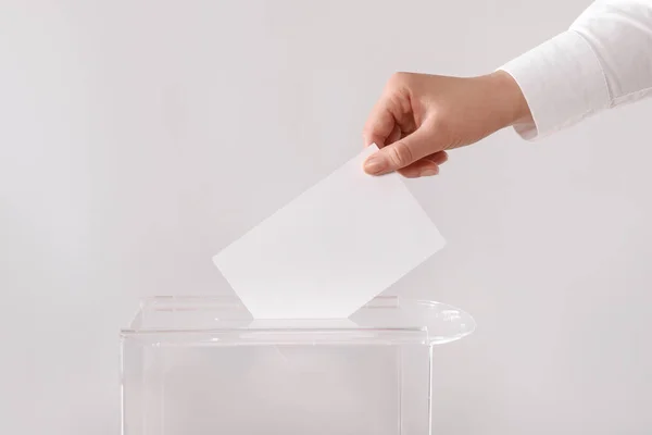 ライトグレーの背景に投票ボックスに彼女の投票を置く女性 クローズアップ — ストック写真
